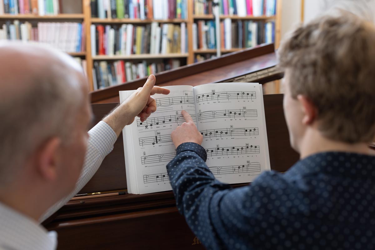 Peter Muir with John in a lesson looking at sheet music